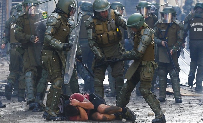 Police officers beat up a citizen during an anti-government protest, Chile.