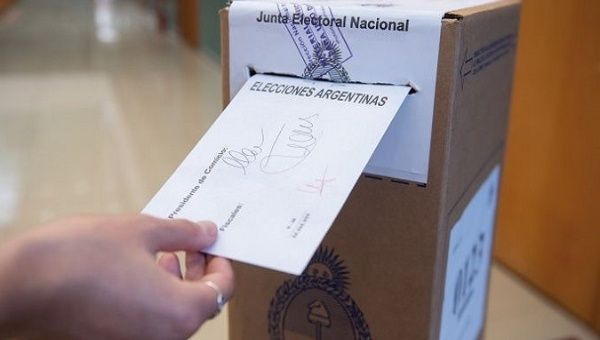 A citizen enters her ballot at a voting booth, Argentina. 