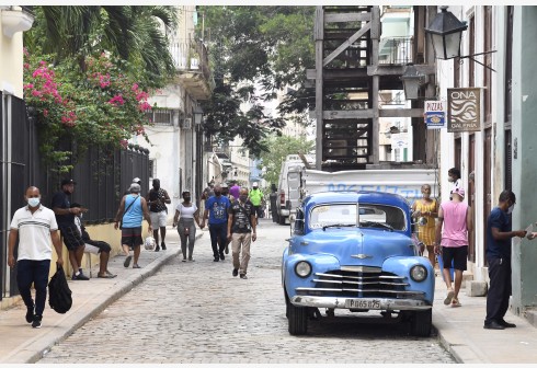 People wearing face masks walk on the street in Havana, Cuba, Sept. 25, 2021.