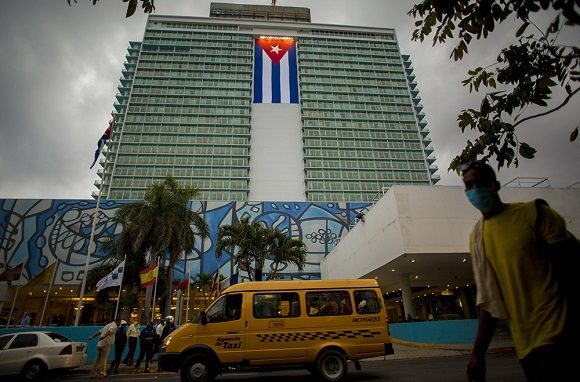 The largest Cuban flag in Cuba being displayed on the facade of the Havana Libre Hotel.