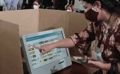 A woman sees information in a voting machine, Venezuela, November 2021. 