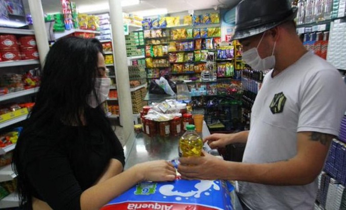 Customers check prices in a supermarket, Colombia, Dec. 2021.