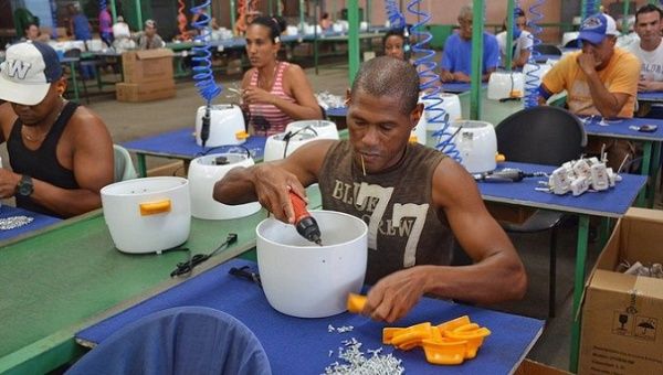 Workers make rice cookers, Cuba.