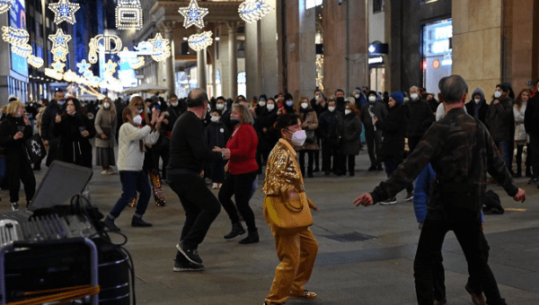 People dance on a street in Milan, Italy, Jan. 6, 2022.