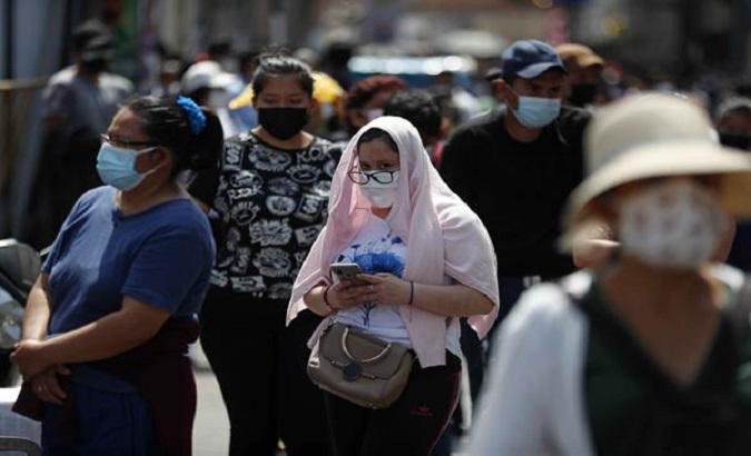 People walk down a street, Lima, Peru, Jan. 4, 2022.