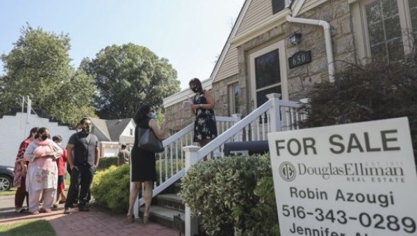 Robin Azougi (1st R), a licensed real estate salesperson with Douglas Elliman Real Estate, talks with prospective buyers at a house for sale in Floral Park, Nassau County, New York, the United States, on Sept. 6, 2020.