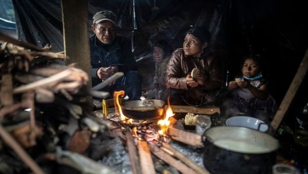 Indigenous people cook on a makeshift stove, Bogota, Colombia. 