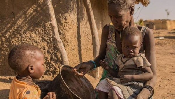 An African mother feeds her children.