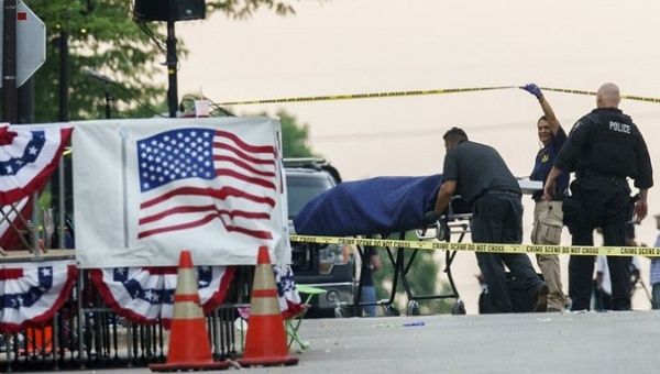 Paramedics remove the body of one of the victims, Highland Park, Illinois, U.S., July 4, 2022.