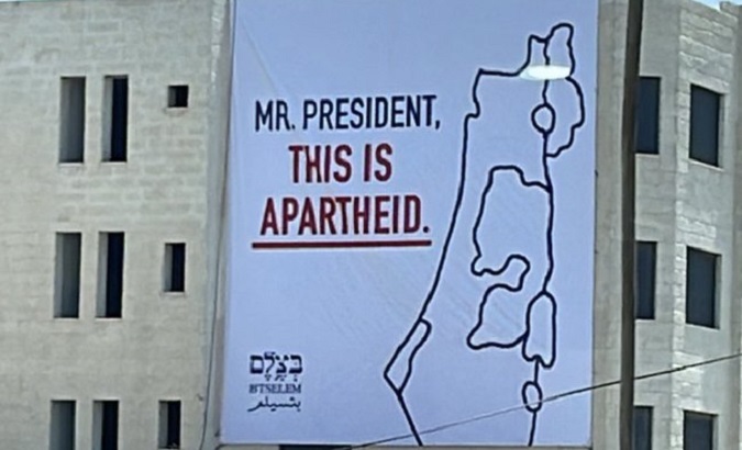A banner hangs from a building at occupied Palestinian territory, July 13, 2022.