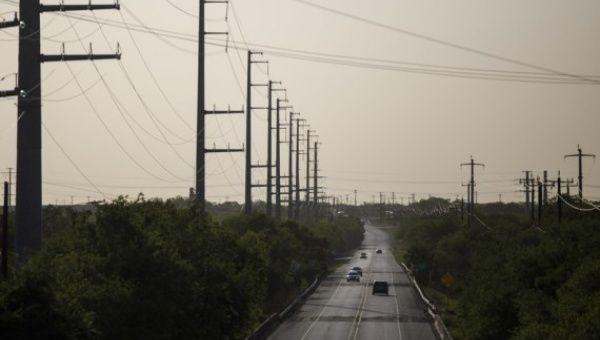 Vehicles run on a road next to power transmission lines in San Antonio, Texas, the United States, on July 18, 2022.
