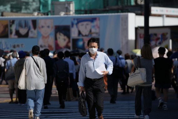 People wearing face masks walk on a street in Tokyo, Japan, July 29, 2022.