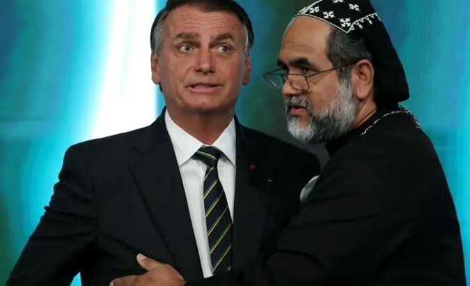 Father Kelmo (R) hugging his alleged presidential rival Jair Bolsonaro (L), Sept. 29, 2022.