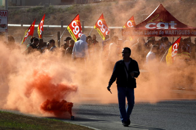 Workers from TotalEnergies and Esso ExxonMobil release colored smoke bomb during a protest called by CGT union outside TotalEnergies refinery in La Mede, Chateau Neuf les Martigues, France, 11 October 2022