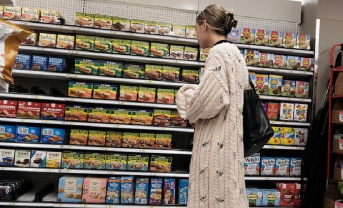 A woman looks at the prices of products on a shelf, Italy, Nov. 2022.