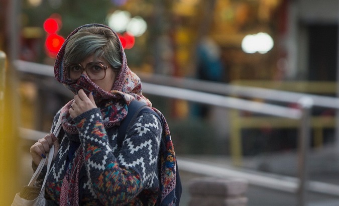 A woman covers her nose to avoid the risks of air pollution.