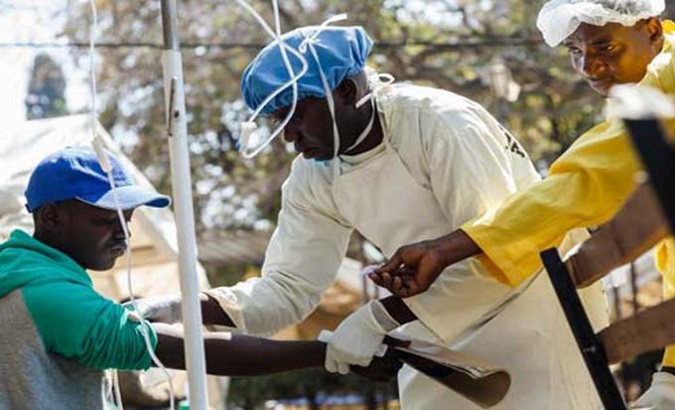 A health assistant administers an intravenous drip on a cholera patient, Malawi.
