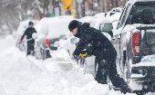 A man shovels snow off a road, Canada. 