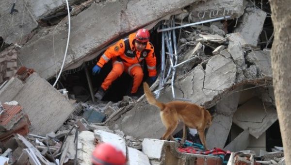 A rescuer searches for survivors among the rubble of a building destroyed in a powerful earthquake in Kahramanmaras, Türkiye, on Feb. 7, 2023.