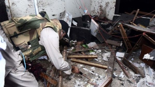 A security man examines a police building following an attack in Karachi, Pakistan, on Feb. 17, 2023.