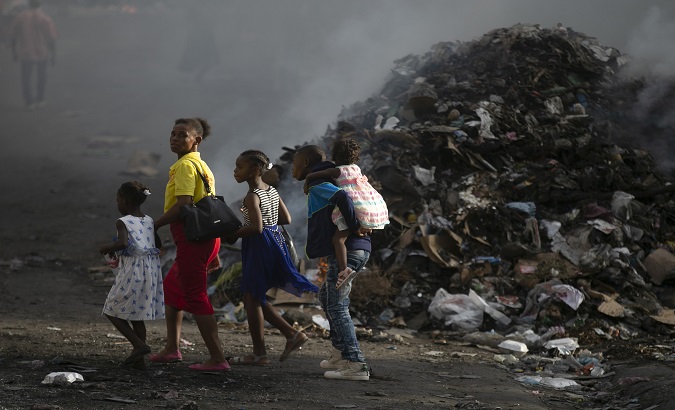 A Haitian family walks through an area devastated by violence, Haiti.