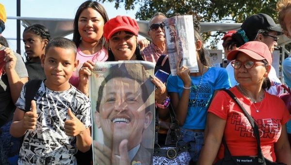 A Venezuelan citizen holds a photograph of the late President Hugo Chavez, 2023.