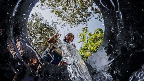 A resident pours water into a bucket, Quezon City, the Philippines, March 22, 2023.