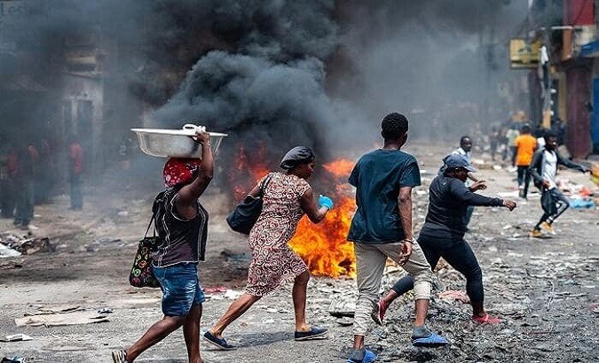 Haitians walk down a street attacked by gangs.