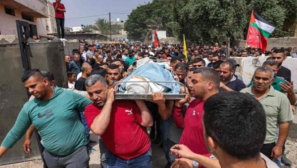 Palestinians march with the body of the 15-year-old teenager killed in Jericho town, March 10, 2023.  