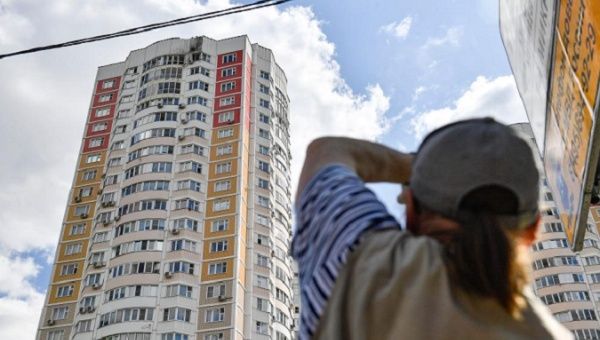 A citizen looks at the damage caused by drones to a building in Moscow, Russia, May 30, 2023.