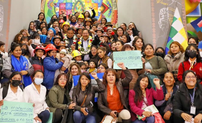 Bolivian President Luis Arce (C) and working women in La Paz, July 10, 2023.