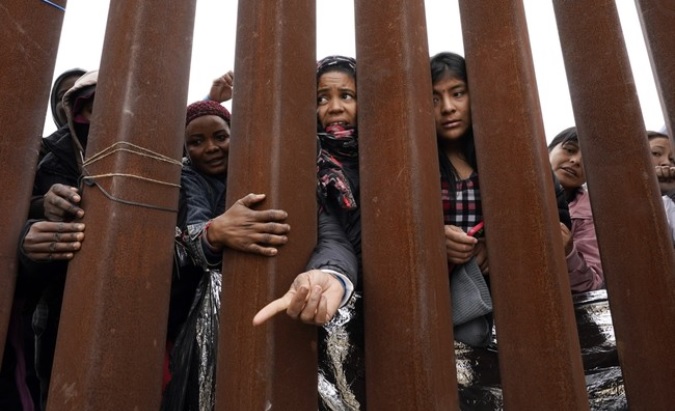 Migrants at the U.S. border wall, 2023.