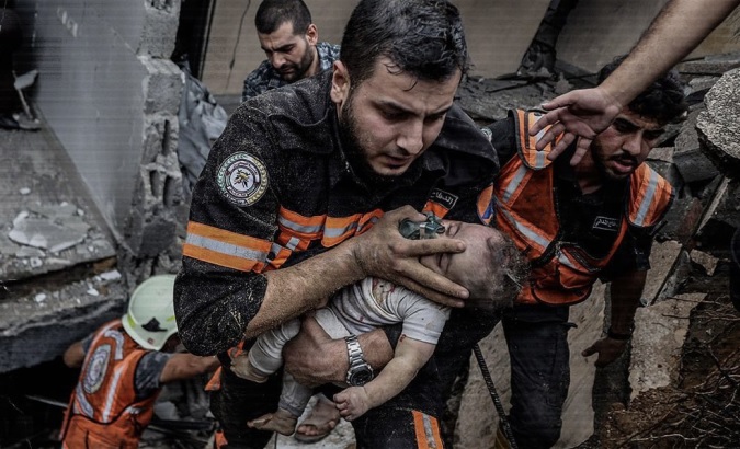Child is rescued from the rubble caused by the Israeli bombing in Gaza, Oct. 2023.