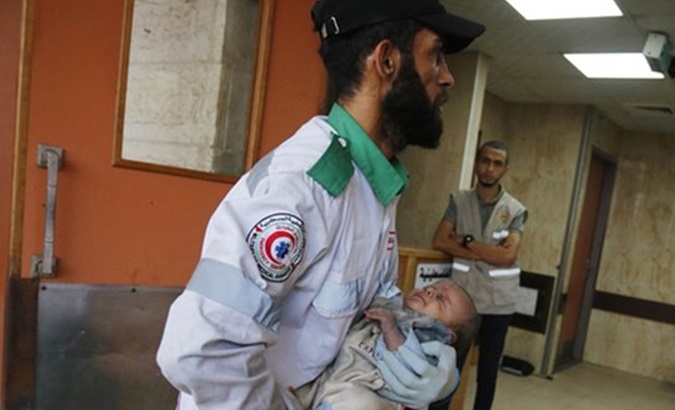 Paramedic carries a Palestinian child to a hospital in Gaza, Oct. 23, 2023.