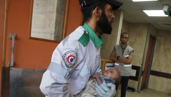 Paramedic carries a Palestinian child to a hospital in Gaza, Oct. 23, 2023.
