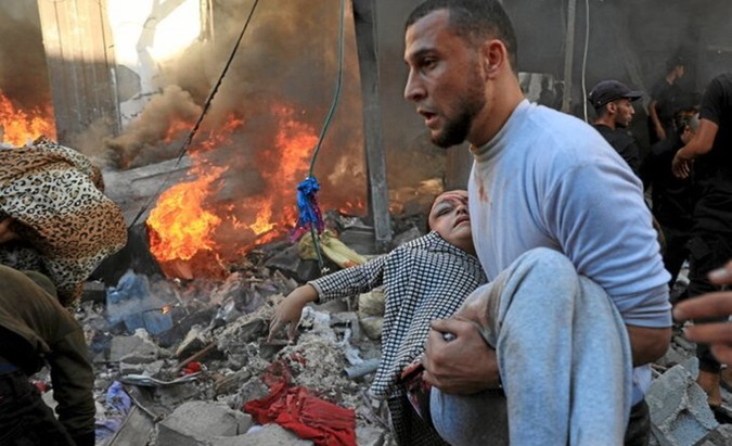 A Palestinian helps a child after an Israeli bombing in Gaza, Dec. 2023.
