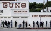 People wait for the opening of a weapons store.
