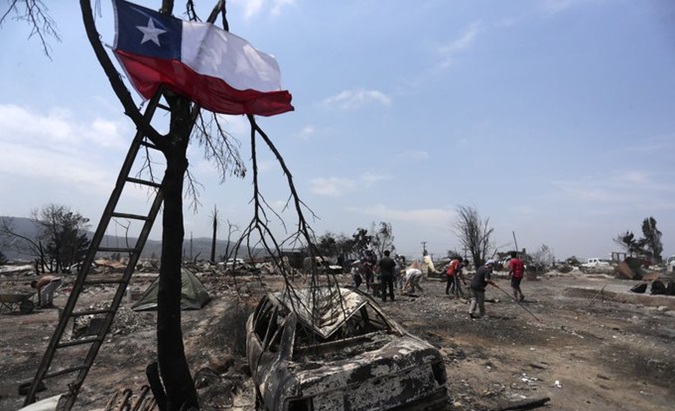 Chileans collect debris caused by a fire, Feb. 4, 2024.