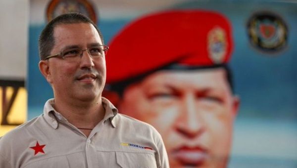 Jorge Arreaza in front of a giant photograph of Commander Hugo Chavez.
