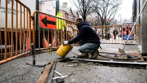 A construction worker fixes a sidewalk in New York, U.S.. 